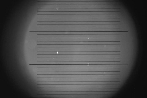 Geladenes Öltropfchen beim Millikan Experiment, wie es durch das Mikroskop gesehen wird. 