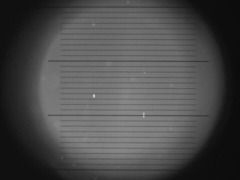 Geladenes Öltropfchen beim Millikan Experiment, wie es durch das Mikroskop gesehen wird. 