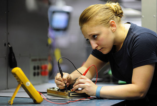 Technikerin überprüft die Widerstände eines Schaltkreises 